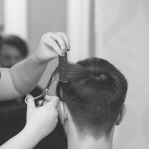 An employee of Sunflower Salon giving a client the men's haircut service.